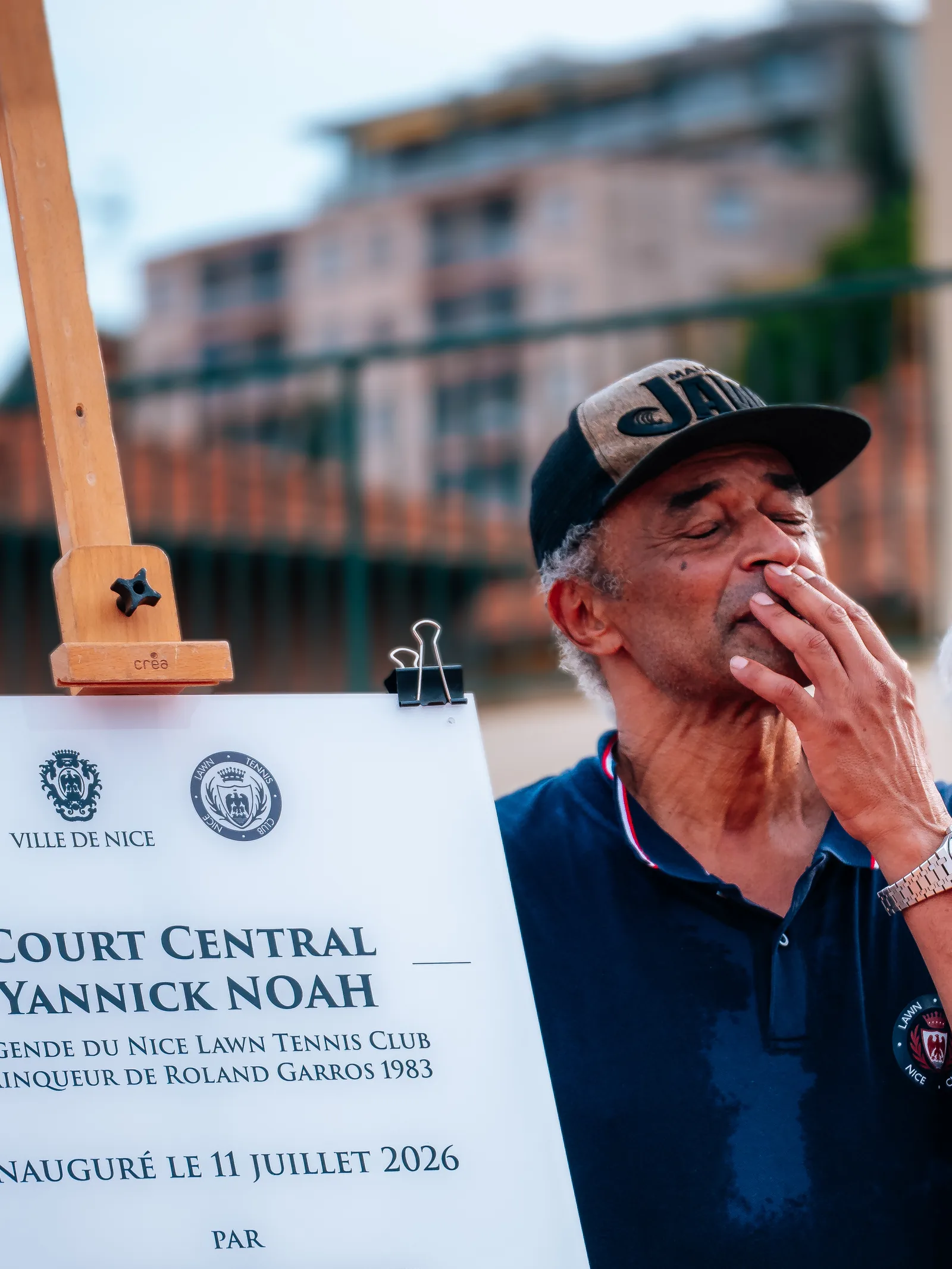 Yannick Noah posant avec la plaque du Court Central à son nom
